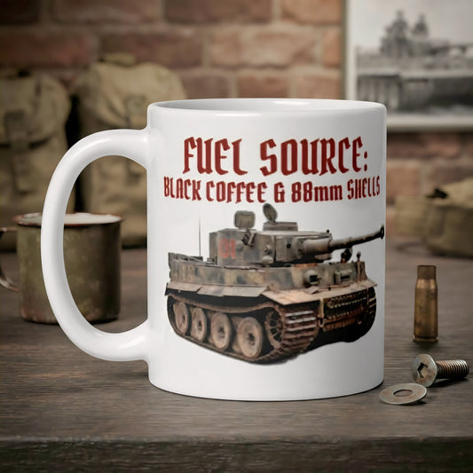 A white ceramic coffee mug with a humorous military-themed graphic. The graphic features red text reading 'FUEL SOURCE: BLACK COFFEE & 88MM SHELLS' above a printed illustration of a German tank.